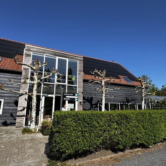 Gebouw met houten gevel en zonnepanelen bij de Zeeuwse Oase